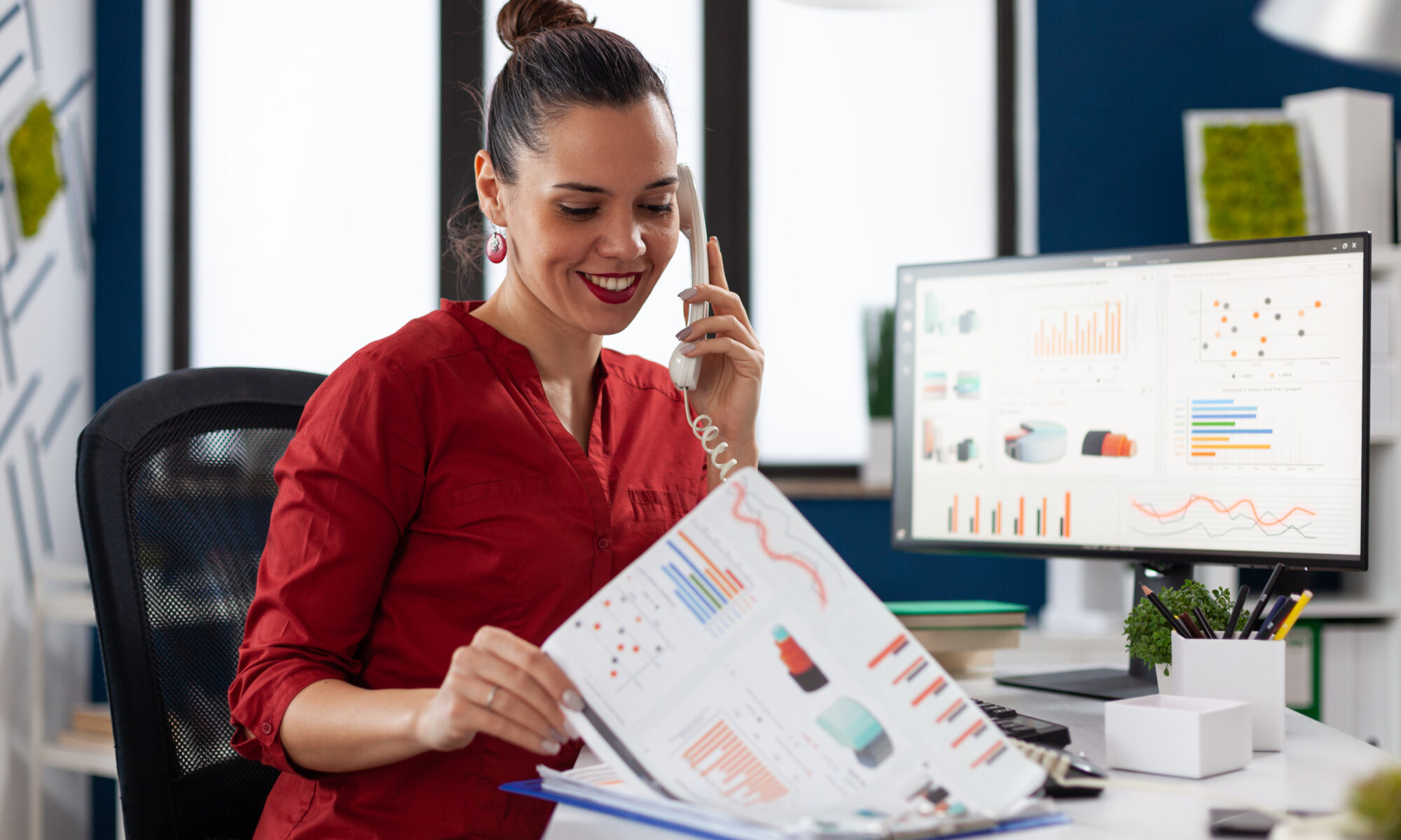 Businesswoman In Company Office Checking Finaicial Statistics - RW Office