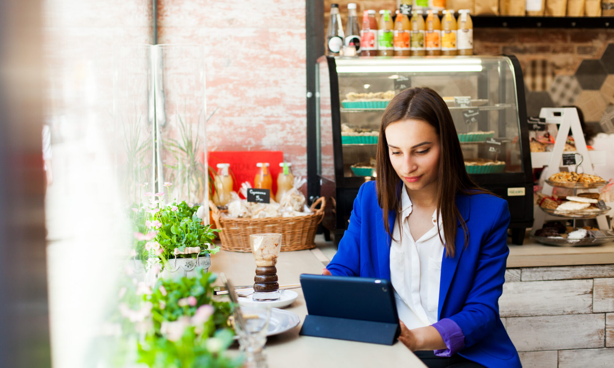 Woman Works With A Tablet At The Table In A Cafe - RW Office